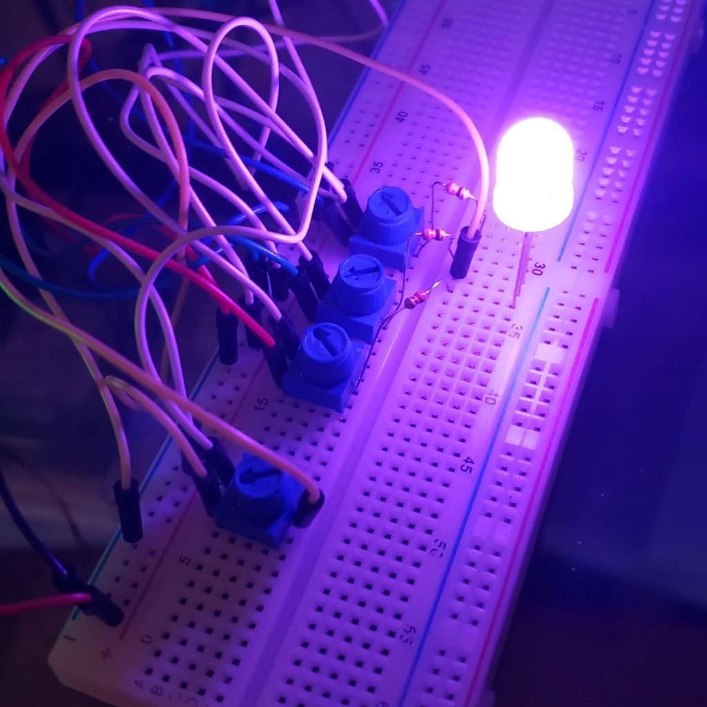 A breadboard with an RGB LED connected to 4 potentiometers